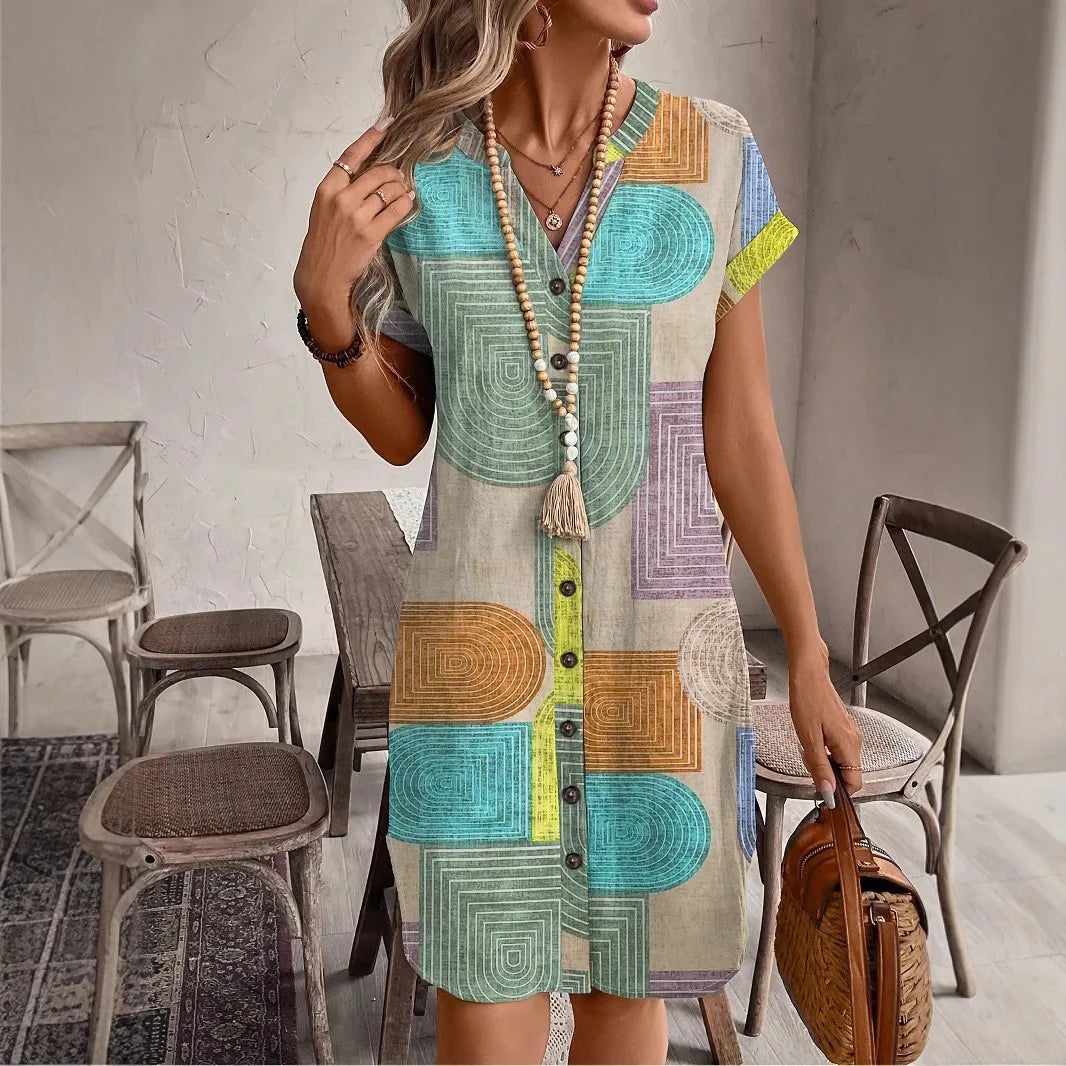 Woman styling a multicolor geometric print button-front dress in an indoor lifestyle setting.