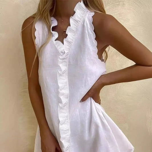 Woman wearing white sleeveless mini dress with ruffled neckline detail for beach party