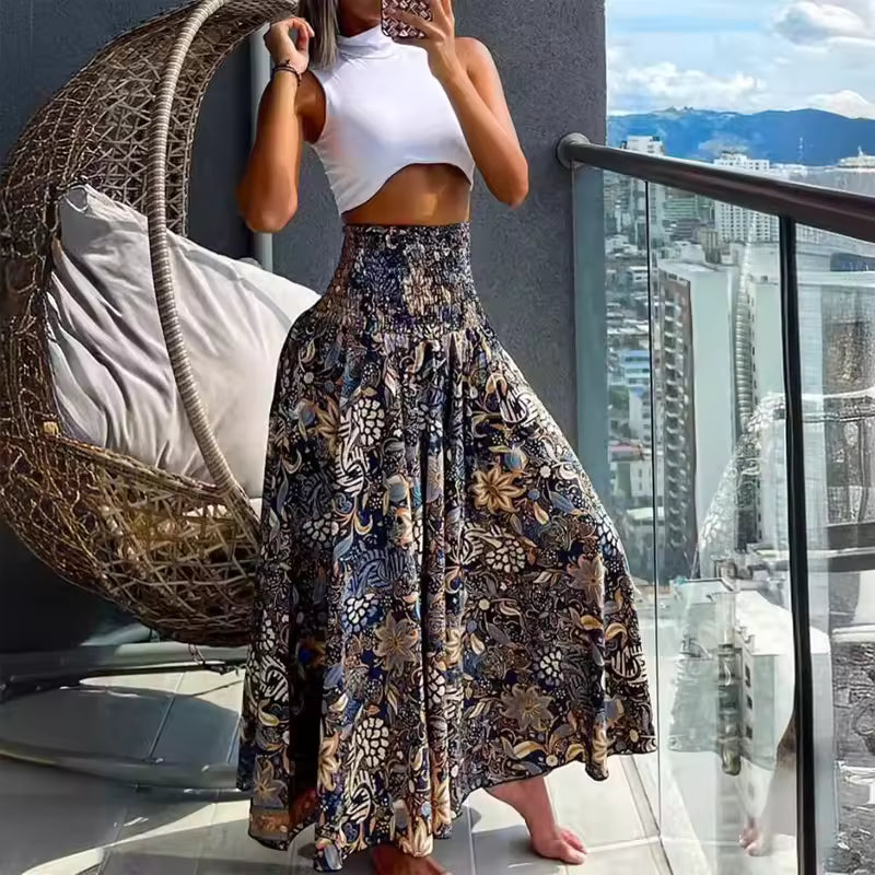 Woman wearing white crop top and A-line floral print maxi skirt in navy, beige, and blue with smocked waist