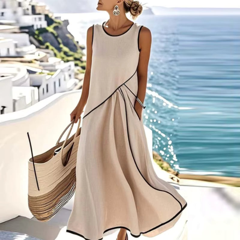 Woman wearing beige, black-trimmed A-line maxi dress with sleeveless design and round neckline