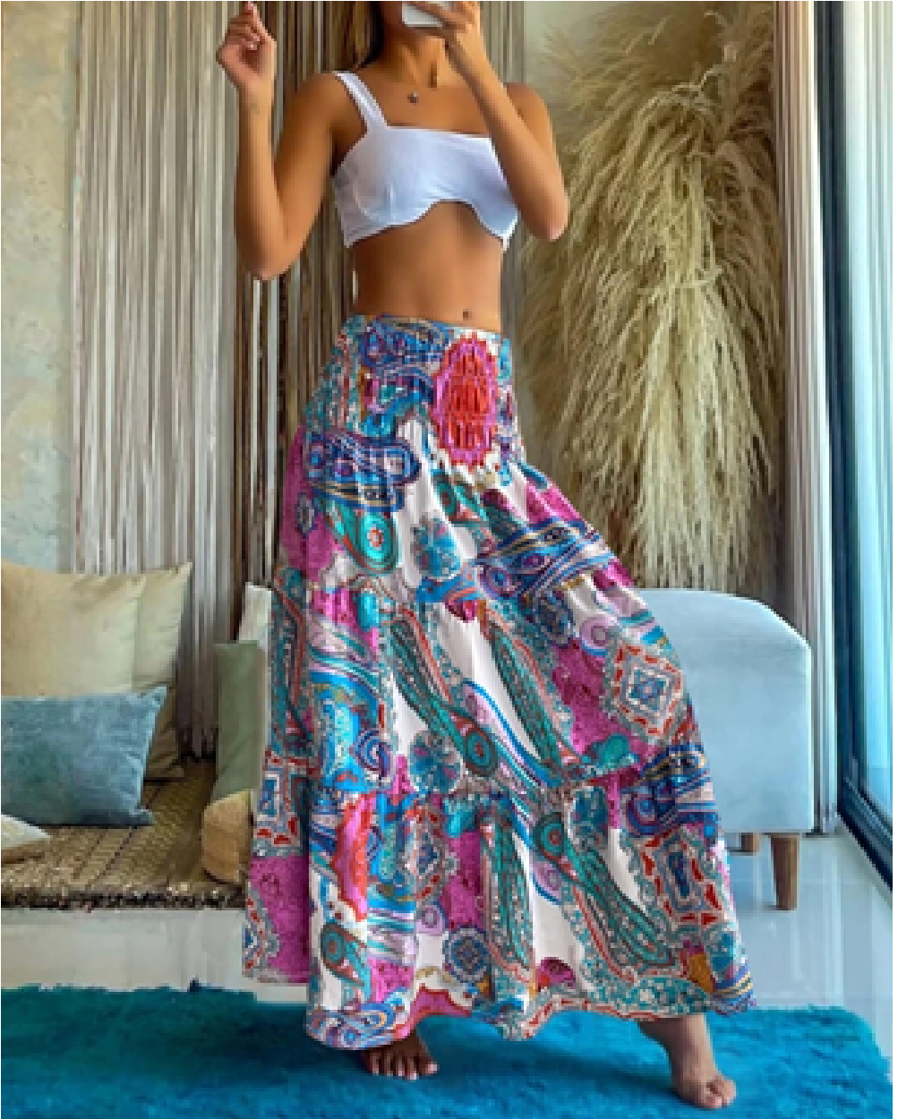 Multicolor paisley print maxi skirt in pink, blue and teal with a smocked waist, shown from the front.