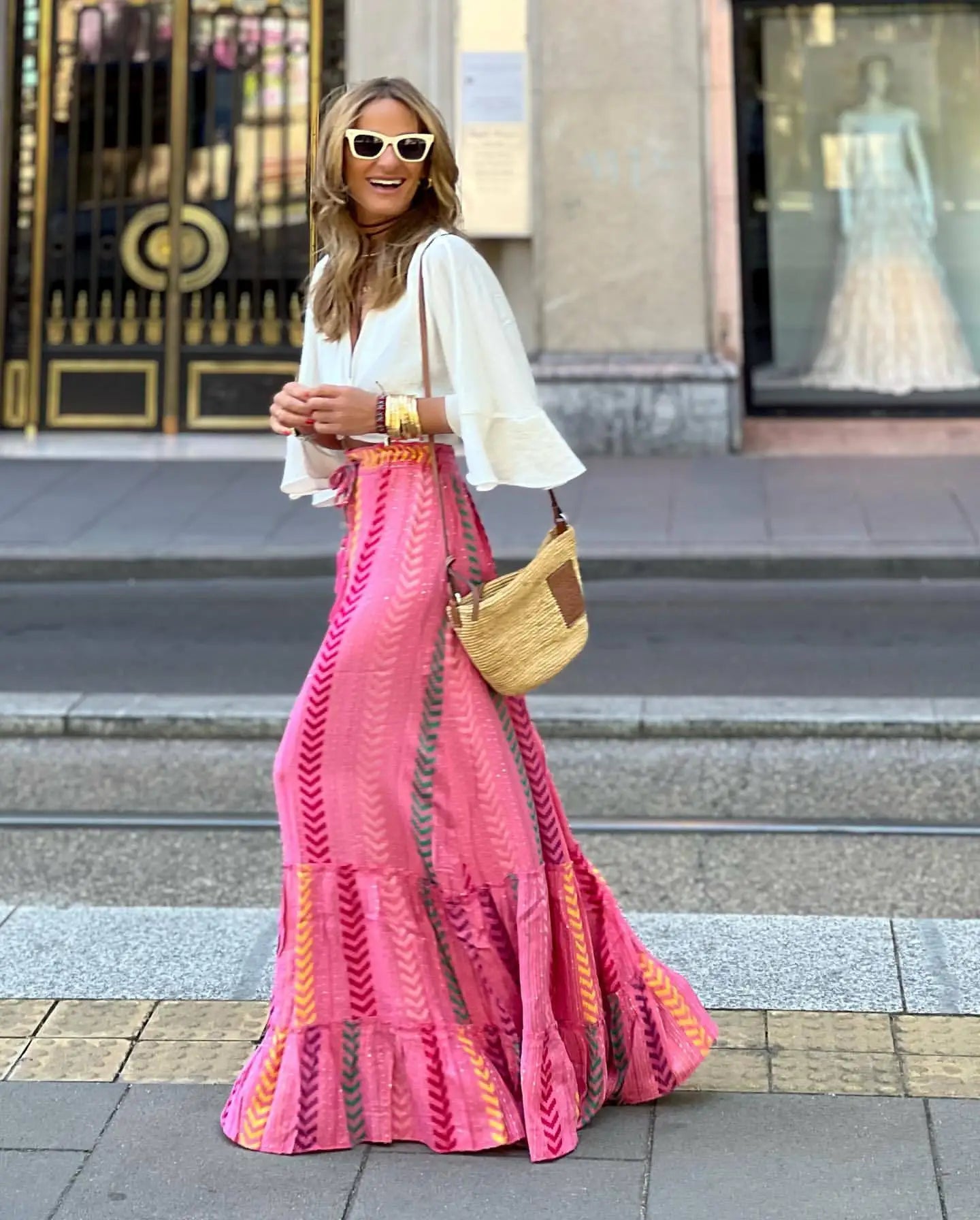  Pink and yellow striped boho maxi skirt with tiered ruffles styled with white bell sleeve blouse