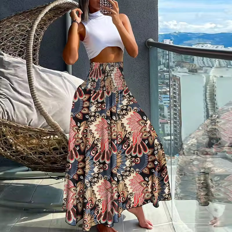 Woman wearing white crop top and A-line patchwork print maxi skirt in coral, navy, and beige with smocked waist
