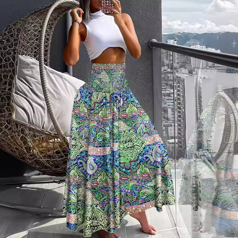 Woman wearing white crop top and A-line patchwork print maxi skirt in green, blue, and pink with smocked waist